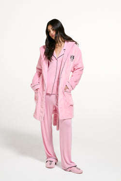 Displays a model wearing the Juicy Pink 'Juicy' branded Plush Crest Robe
