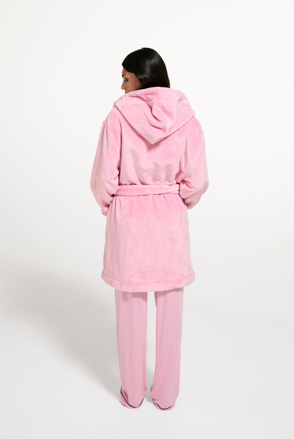 Displays a model wearing the Juicy Pink 'Juicy' branded Plush Crest Robe