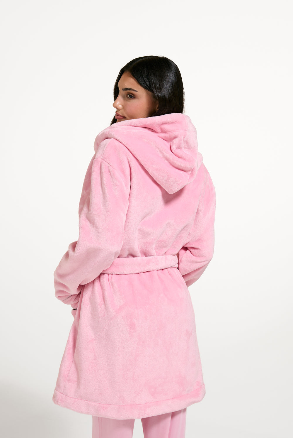 Displays a model wearing the Juicy Pink 'Juicy' branded Plush Crest Robe