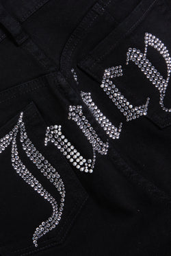Displays a model wearing the Black stretch 'Juicy' branded twill low rise flare jeans featuring the juicy branding 