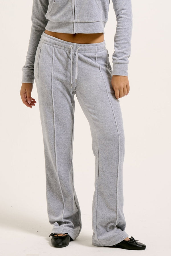 Displays a model wearing the Silver Marl Diamanté 'Juicy' branded cotton velour tracksuit bottom  