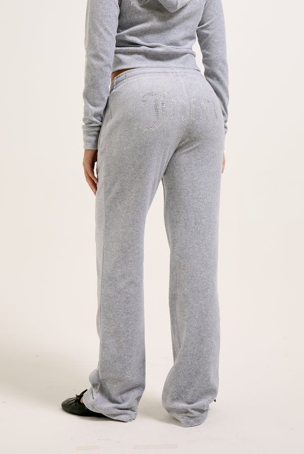 Displays a model wearing the Silver Marl Diamanté 'Juicy' branded cotton velour tracksuit bottom  