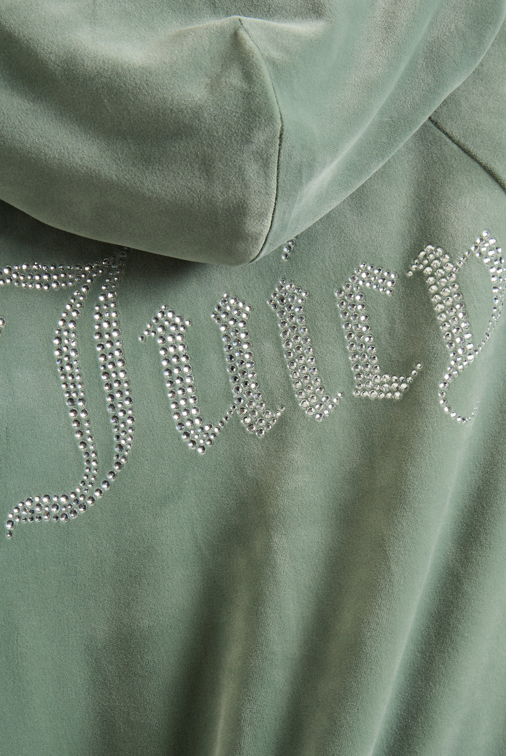 Displays a model wearing the Chinois Green 'Juicy' branded diamanté velour zip-through hoodie featuring the juicy branding 