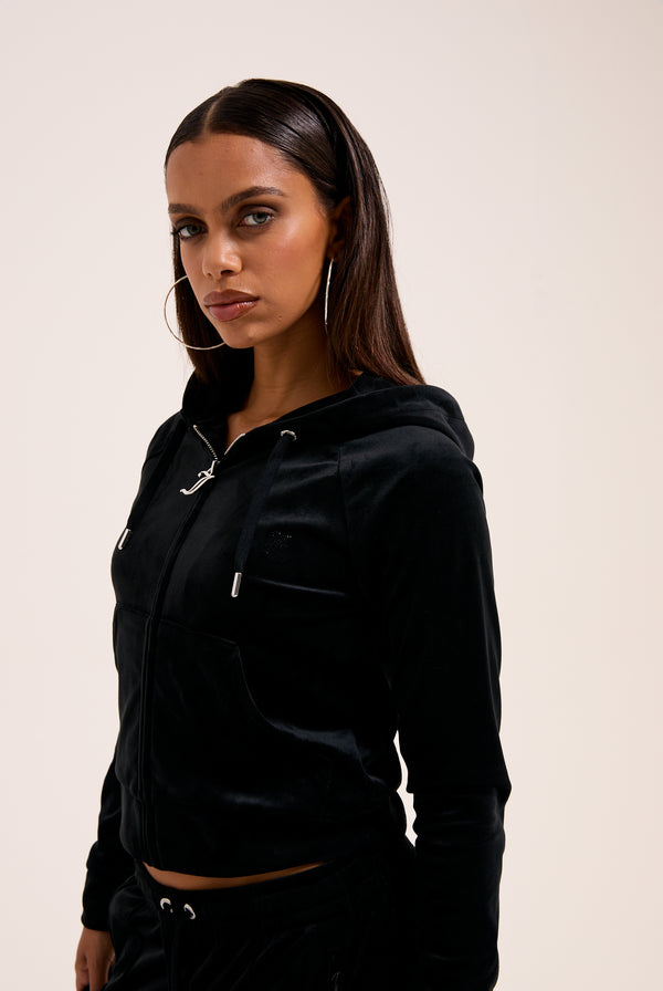 Displays a model wearing the Black 'Juicy' branded outline diamanté velour zip-through hoodie 