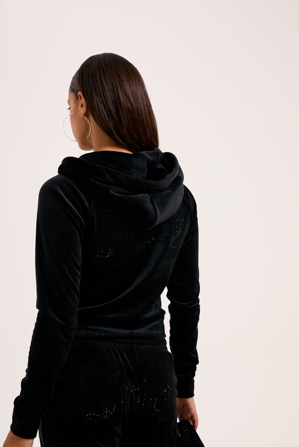 Displays a model wearing the Black 'Juicy' branded outline diamanté velour zip-through hoodie 
