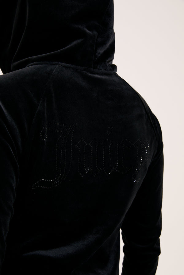 Displays a model wearing the Black 'Juicy' branded outline diamanté velour zip-through hoodie featuring the juicy branding 