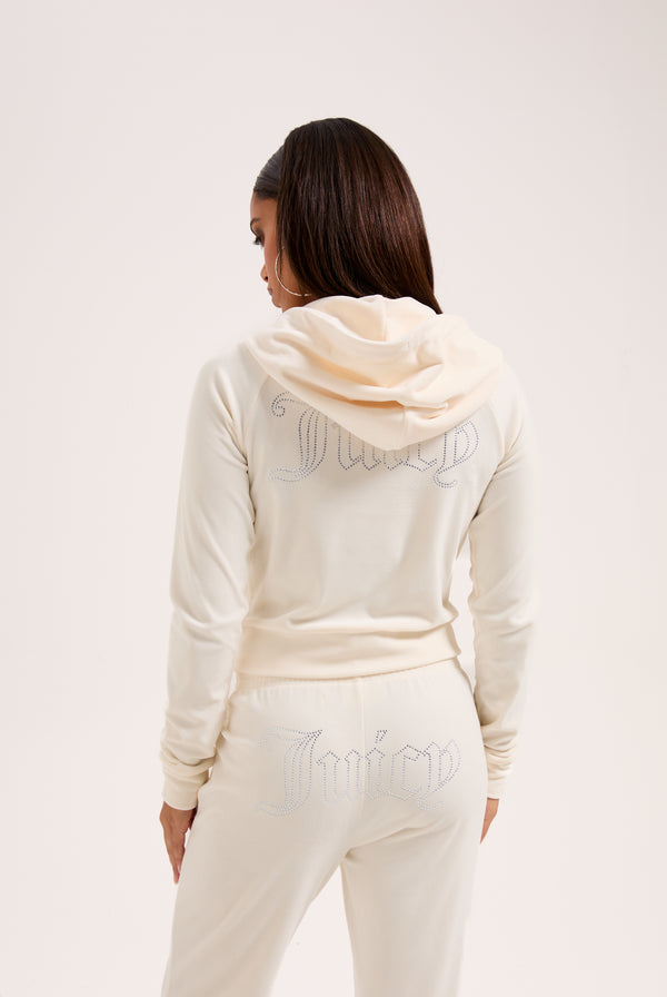 Displays a model wearing the cream 'juicy' branded cream outline diamanté velour zip-through hoodie 