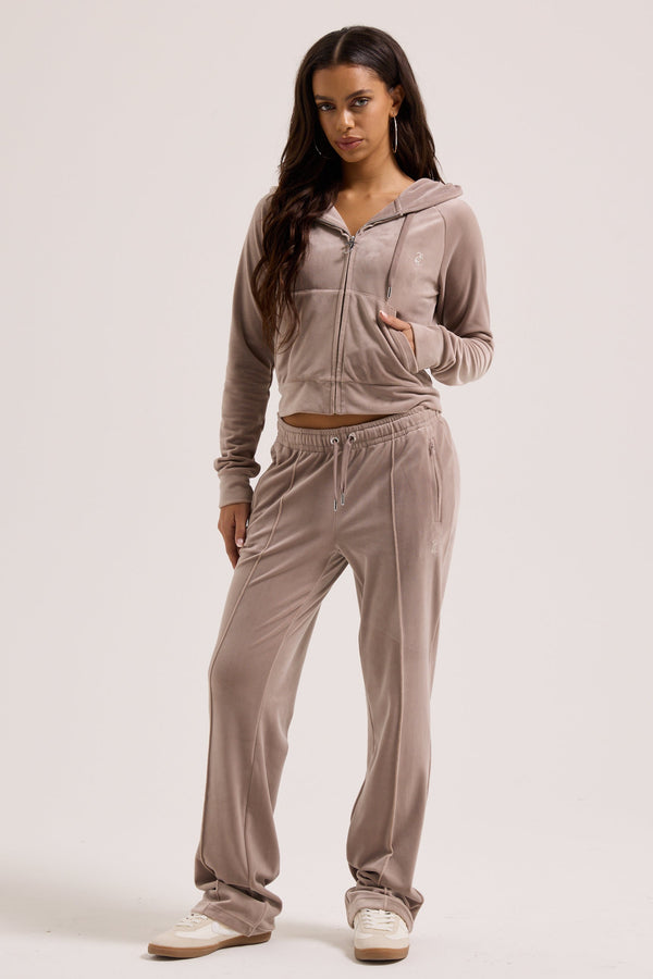 Displays a model wearing the jungle outline 'juicy' branded velour diamanté tracksuit bottom