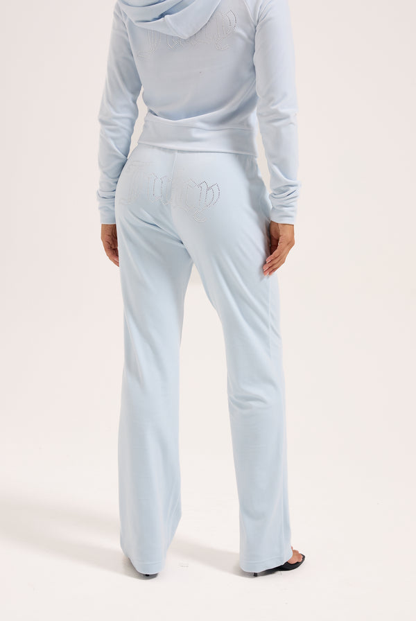 Displays a model wearing the Nantucket Breeze 'Juicy' branded velour outline diamanté tracksuit bottom 
