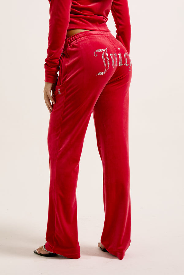 Displays a model wearing the Astor Red Velour 'Juicy' branded Diamanté tracksuit bottoms 
