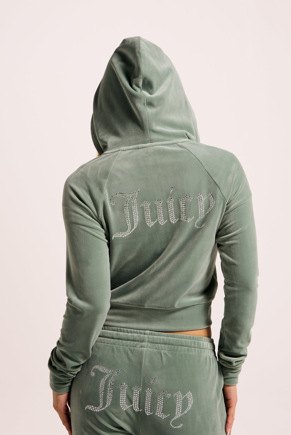 Displays a model wearing the Chinois Green 'Juicy' branded diamanté velour zip-through hoodie 
