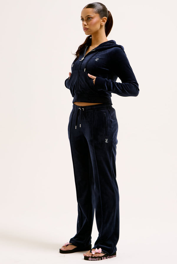 Displays a model wearing the Night Sky 'juicy' branded velour diamanté tracksuit bottom