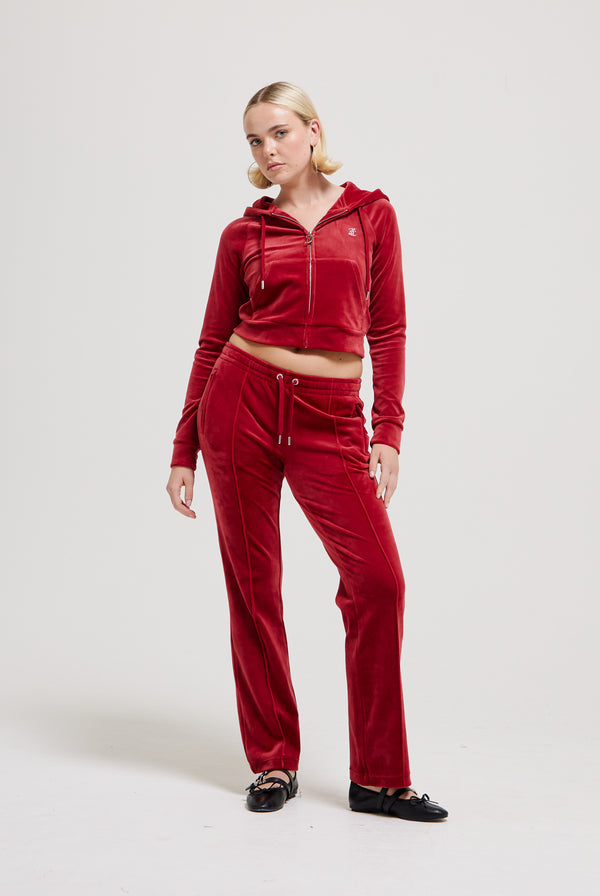 Displays a model wearing the Red Dahlia 'Juicy' branded velour diamanté tracksuit bottom