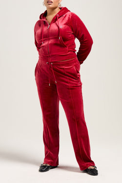 Displays a model wearing the Red Dahlia 'Juicy' branded velour diamanté tracksuit bottom
