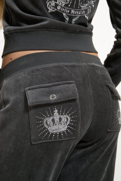 Displays a model wearing the Raven 'Juicy' branded Regal Rebelle Caisa Ultra Low Rise Pant featuring the juicy couture branding 
