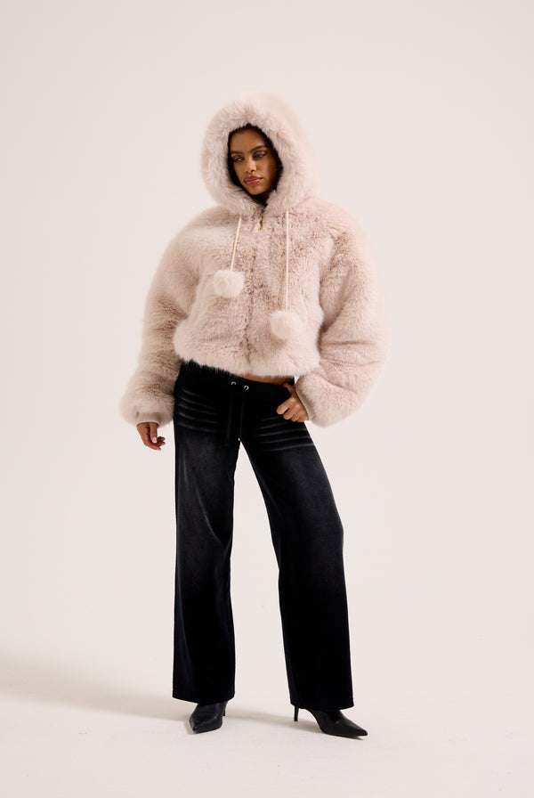 Display a model wearing the cream hooded 'Juicy' branded faux fur jacket 