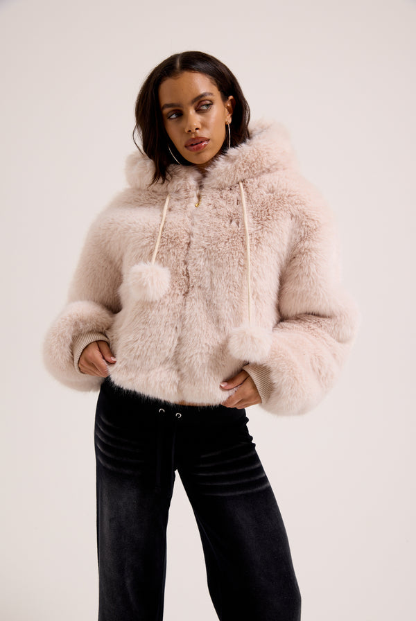 Display a model wearing the cream hooded 'Juicy' branded faux fur jacket 