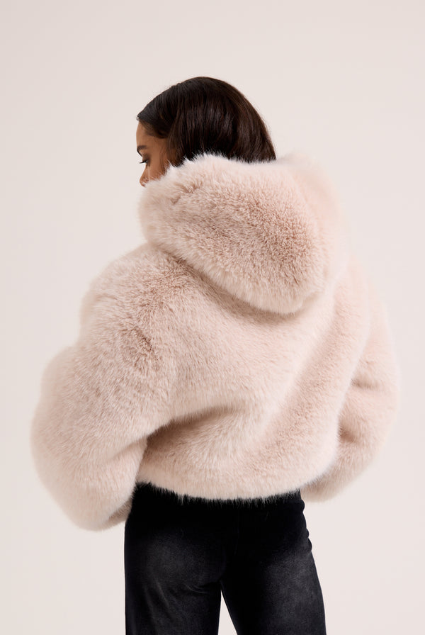 Display a model wearing the cream hooded 'Juicy' branded faux fur jacket 