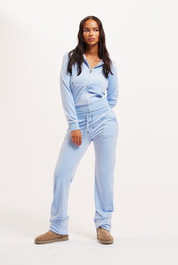 Displays a model wearing the Powder blue classic 'Juicy' branded velour del ray pocketed bottoms 
