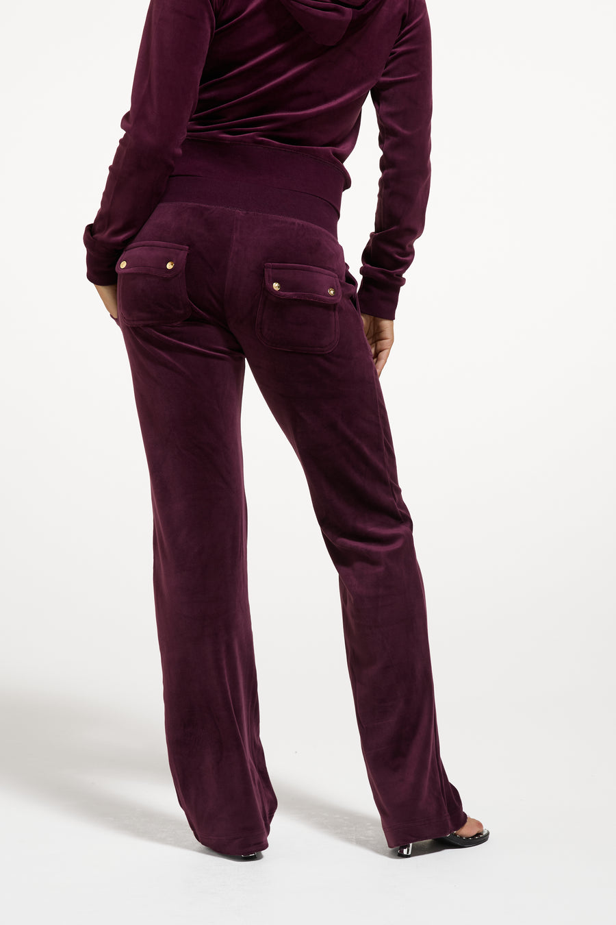 Displays a model wearing the Winetasting / Gold 'juicy' branded Classic Velour Del Ray Pocketed Bottoms