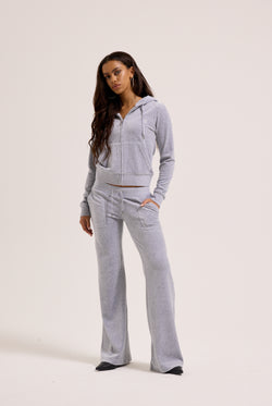 Woman wearing a gray tracksuit on a white background