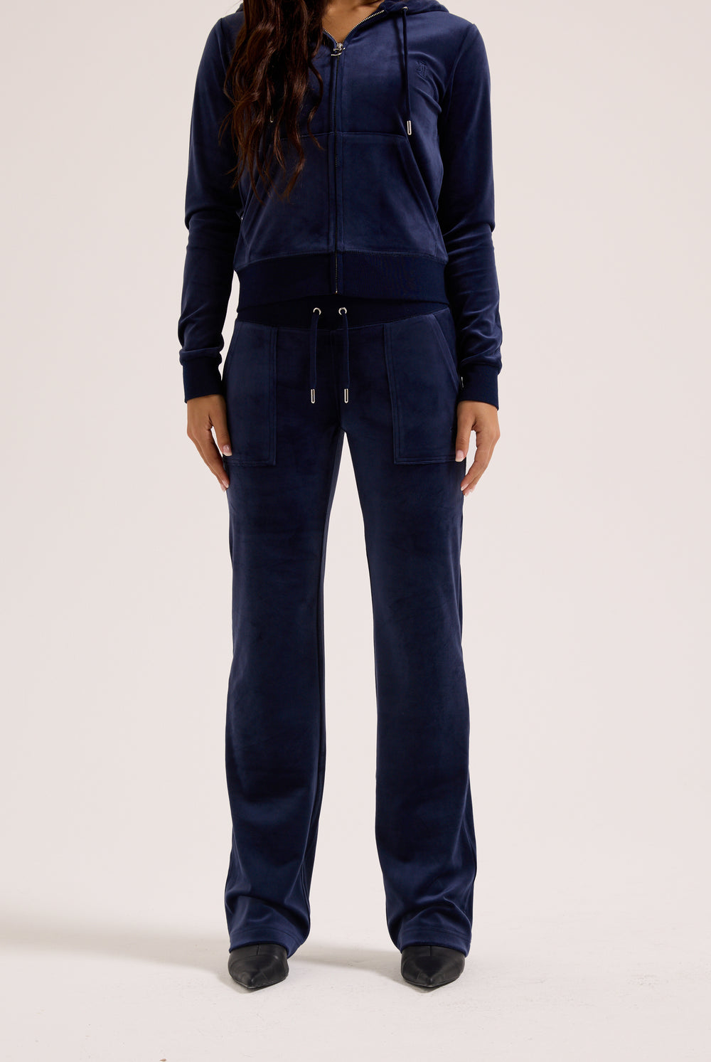 Navy blue tracksuit worn by a person on a white background