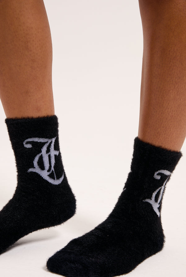 Displays a model wearing the seasonal 'Juicy' branded fluffy sock included in the 2 pack 