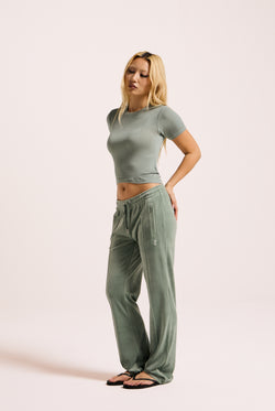 Displays a model wearing the chinois green 'Juicy' velour diamanté tracksuit bottom 