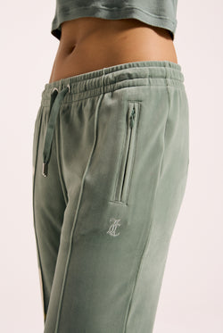 Displays a model wearing the chinois green 'Juicy' velour diamanté tracksuit bottom 