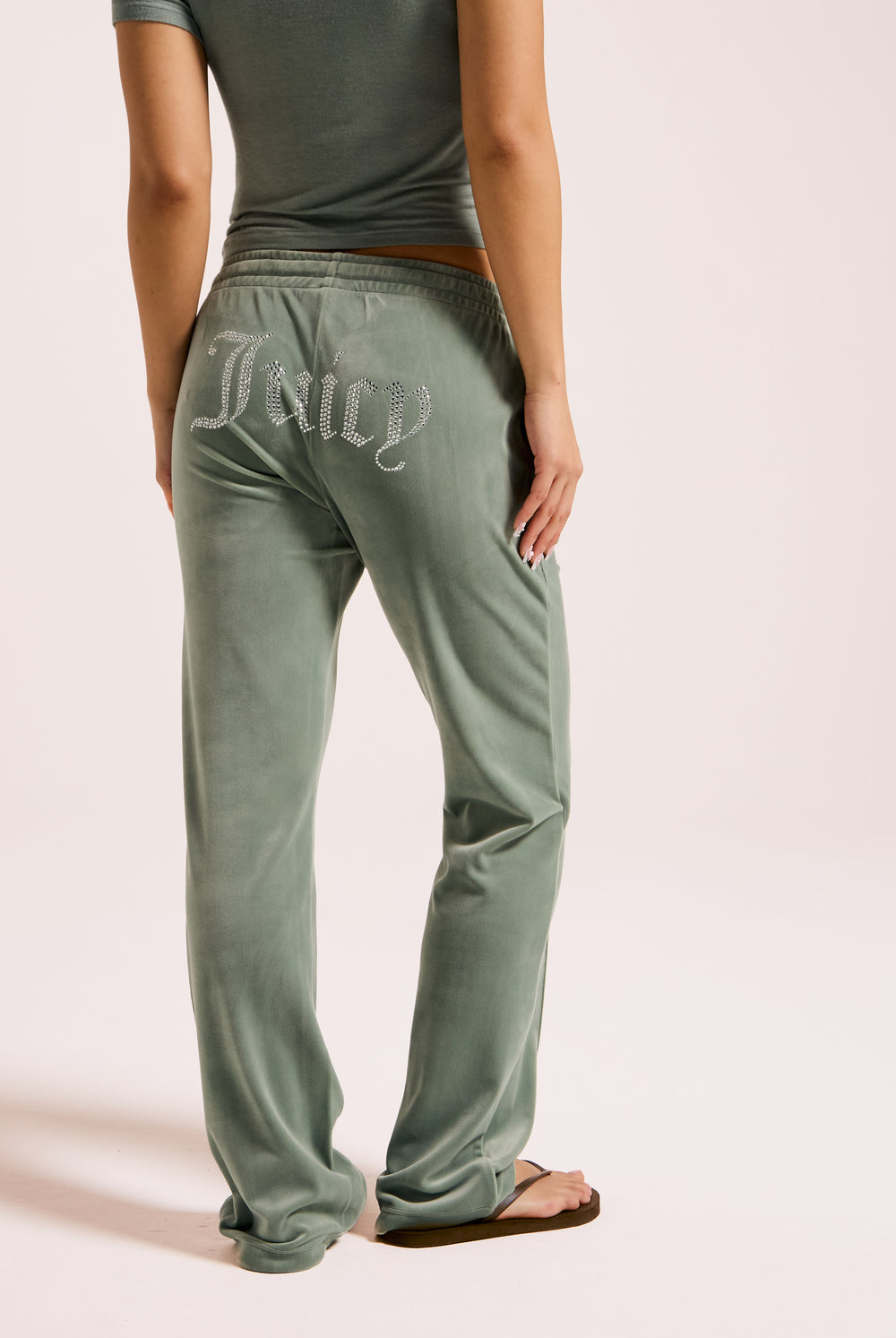 Displays a model wearing the chinois green 'Juicy' velour diamanté tracksuit bottom 