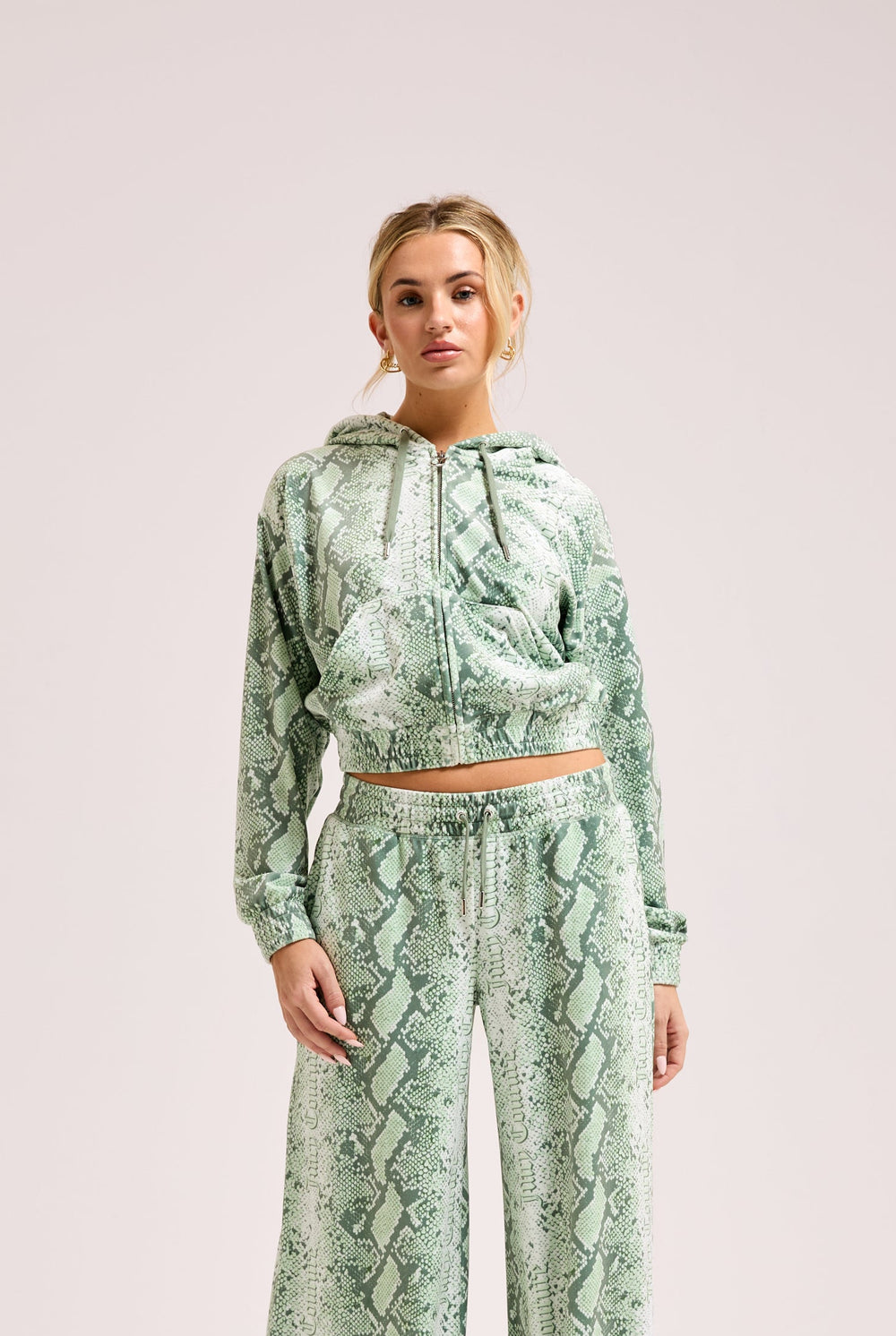 Displays a model wearing the Green snake print 'Juicy' branded diamanté oversized cropped hoodie