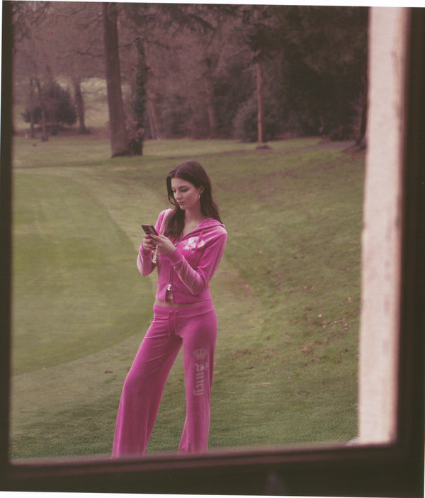Displays a model wearing the super pink 'Juicy' branded diamanté crown OG straight low rise velour bottoms 