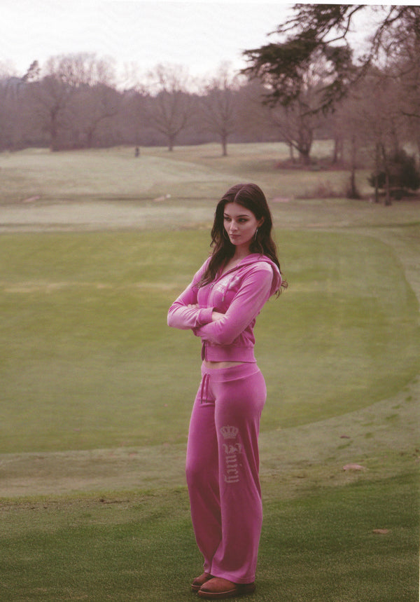 Displays a model wearing the super pink 'Juicy' branded diamanté crown OG straight low rise velour bottoms 