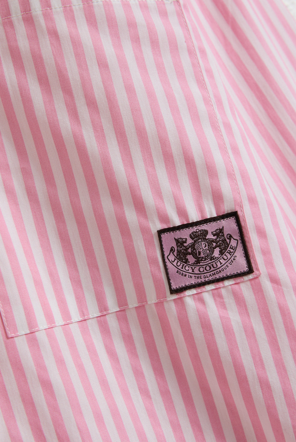 Displays a model wearing the Pink stripe 'Juicy' branded loungewear oversized shirt featuring the juicy Couture logo