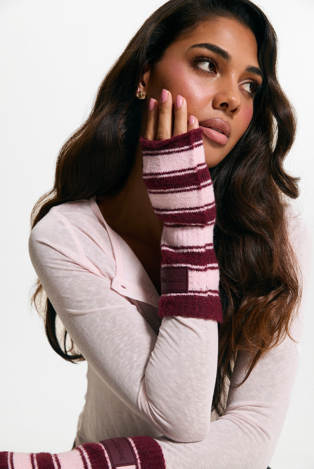 Displays a model wearing the Burgundy Stripe 'Juicy' branded Fingerless Mittens