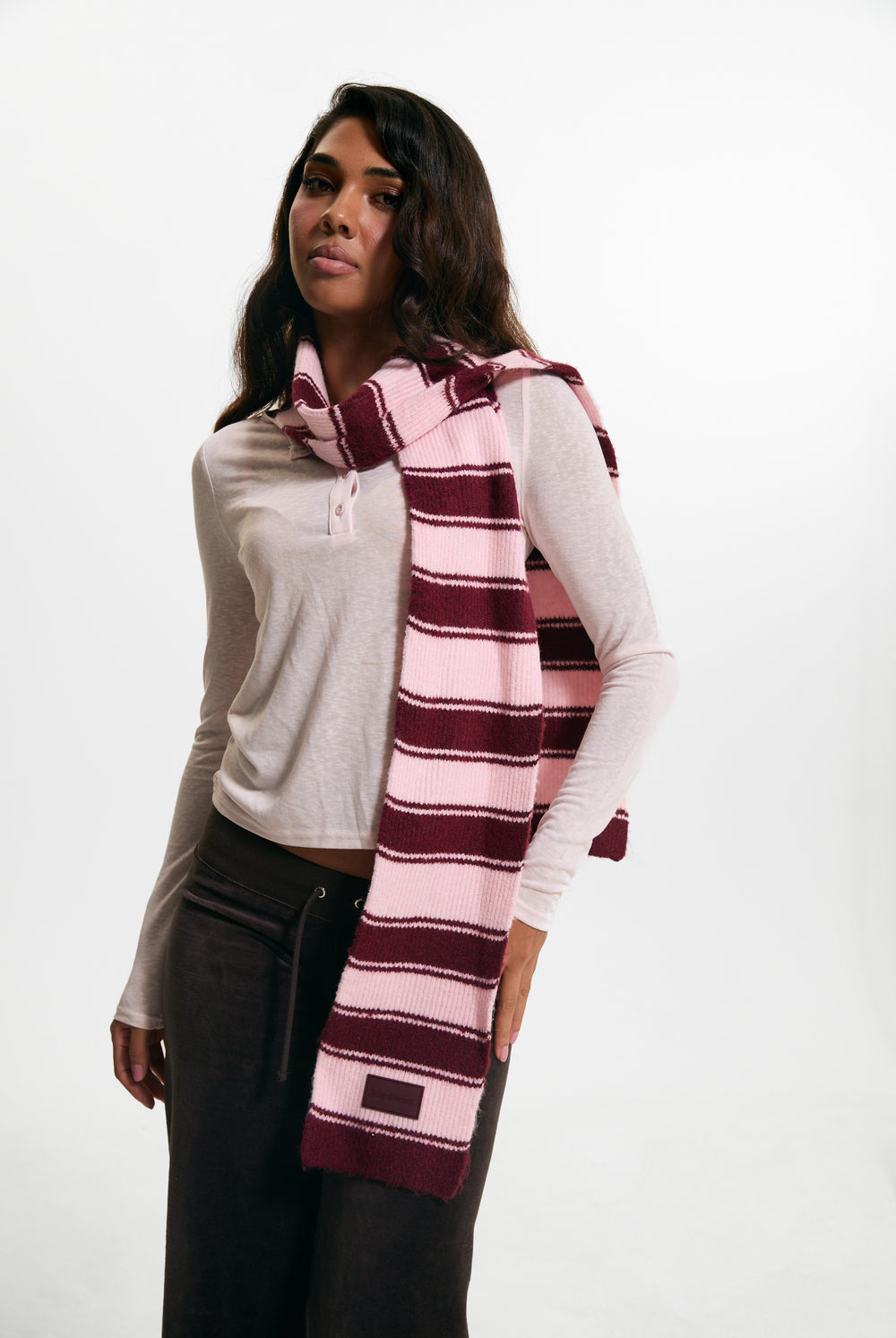 Displays a model wearing the Burgundy 'juicy' branded Stripe Knit Scarf