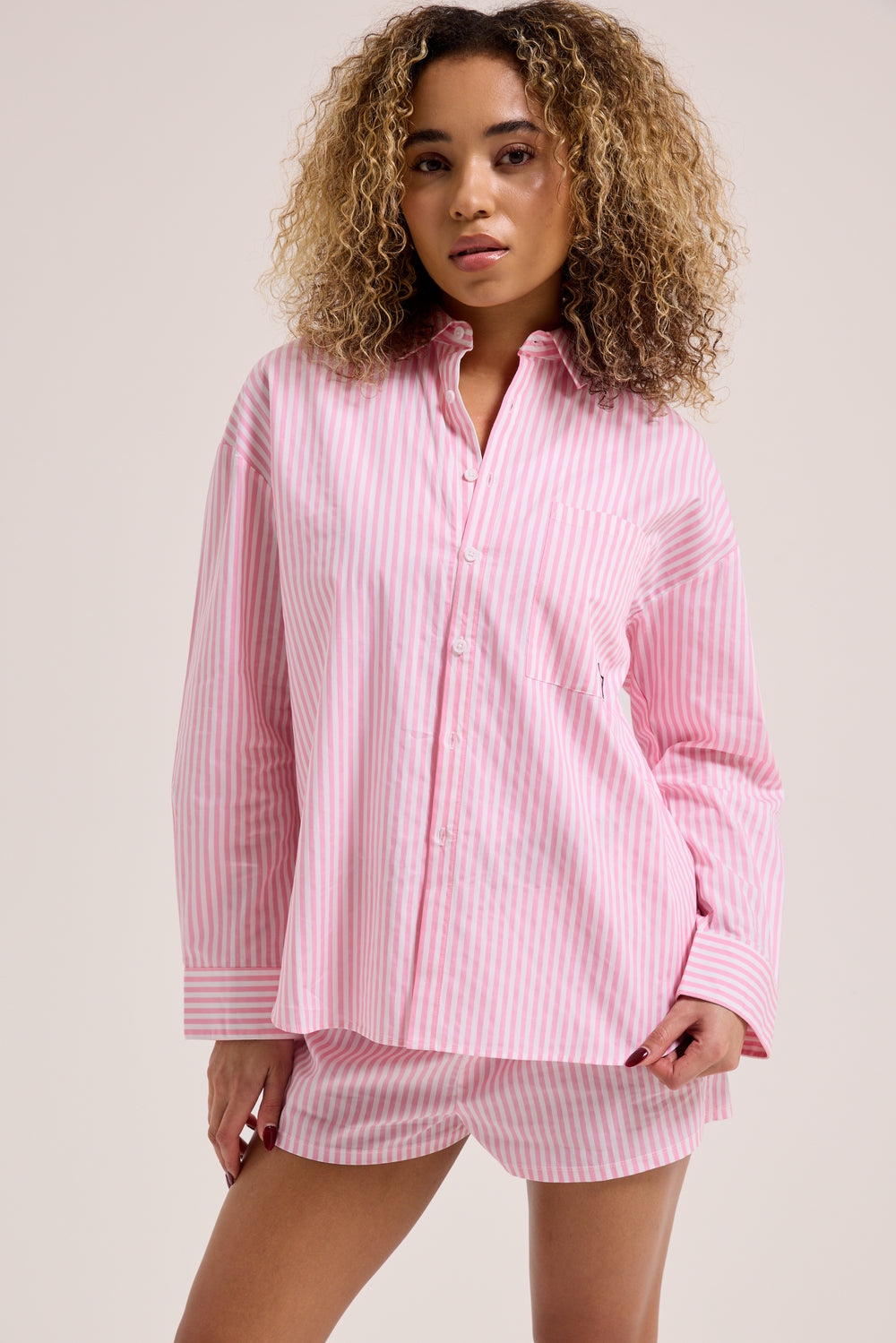 Displays a model wearing the Pink stripe 'Juicy' branded loungewear oversized shirt 