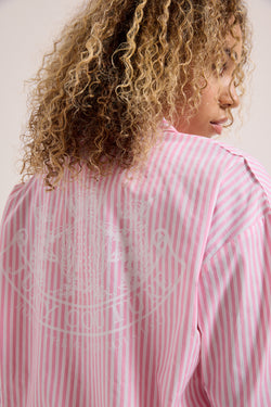 Displays a model wearing the Pink stripe 'Juicy' branded loungewear oversized shirt 