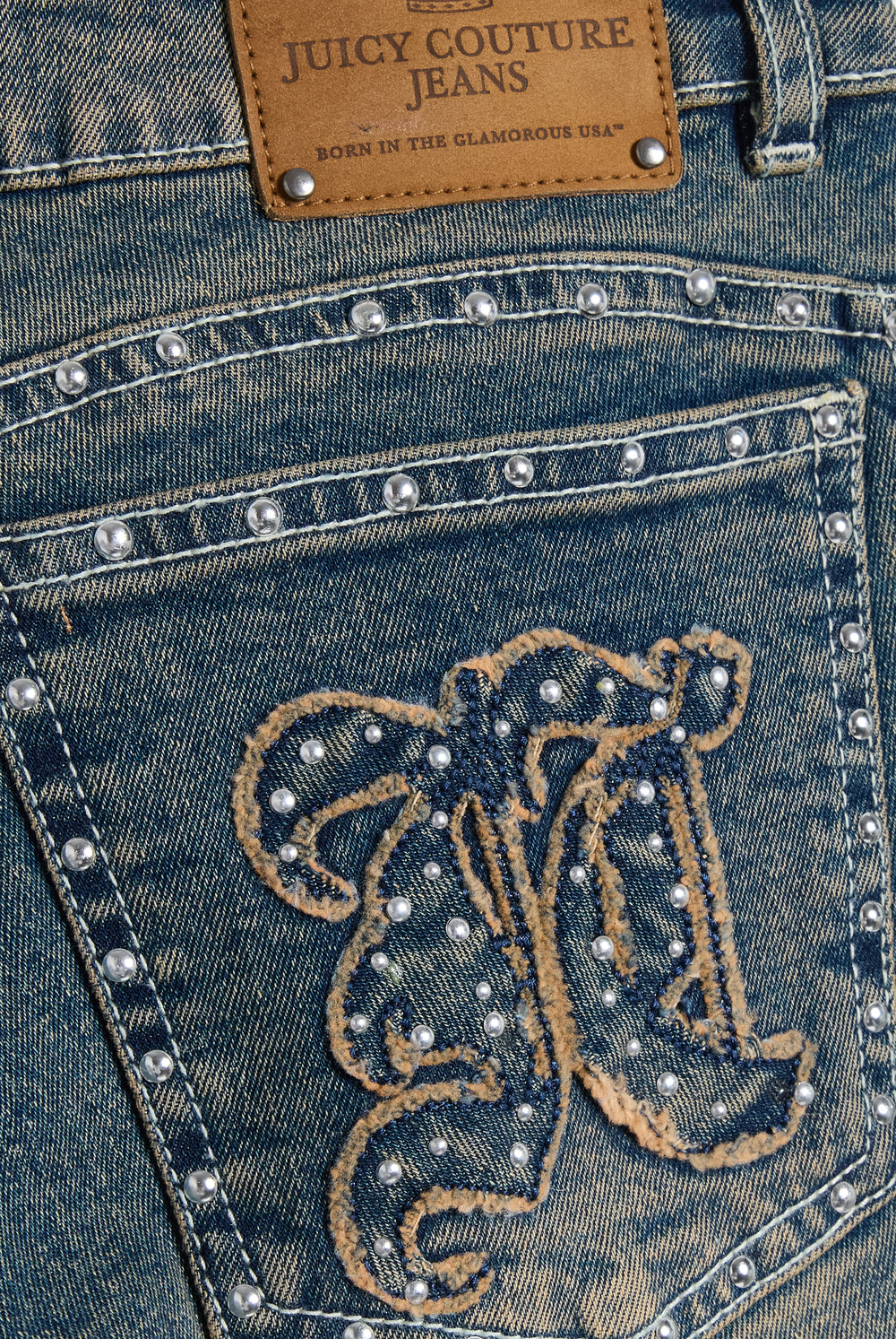 Displays the Mid Wash 'Juicy' branded Sand Stud Moto Bootcut Jeans featuring the details on the juicy Couture logo branding 