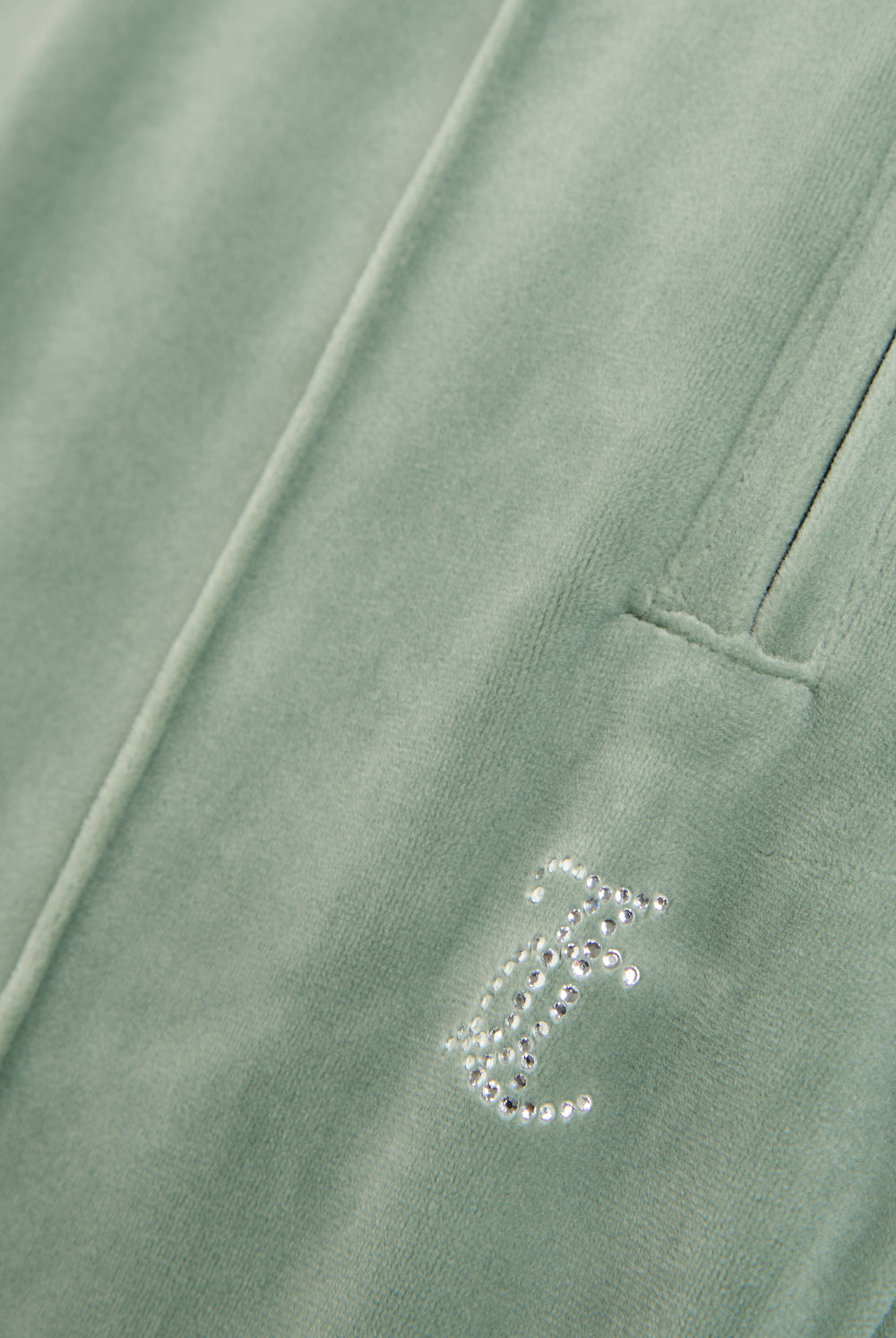 Displays the chinois green 'Juicy' velour diamanté tracksuit bottom featuring the juicy Couture logo