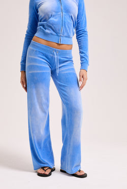 Displays a model wearing the Regatta washed 'Juicy' branded OG straight track pant