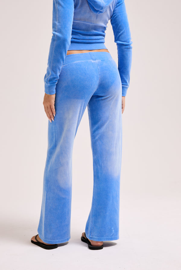 Displays a model wearing the Regatta washed 'Juicy' branded OG straight track pant
