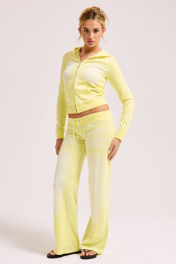Displays a model wearing the Yellow pear washed 'Juicy' branded OG straight track pant 