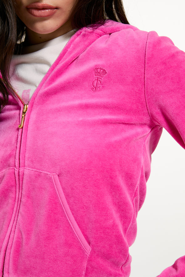 Displays a model wearing the Nostalgia Pink 'Juicy' branded Washed Robyn Hoodie