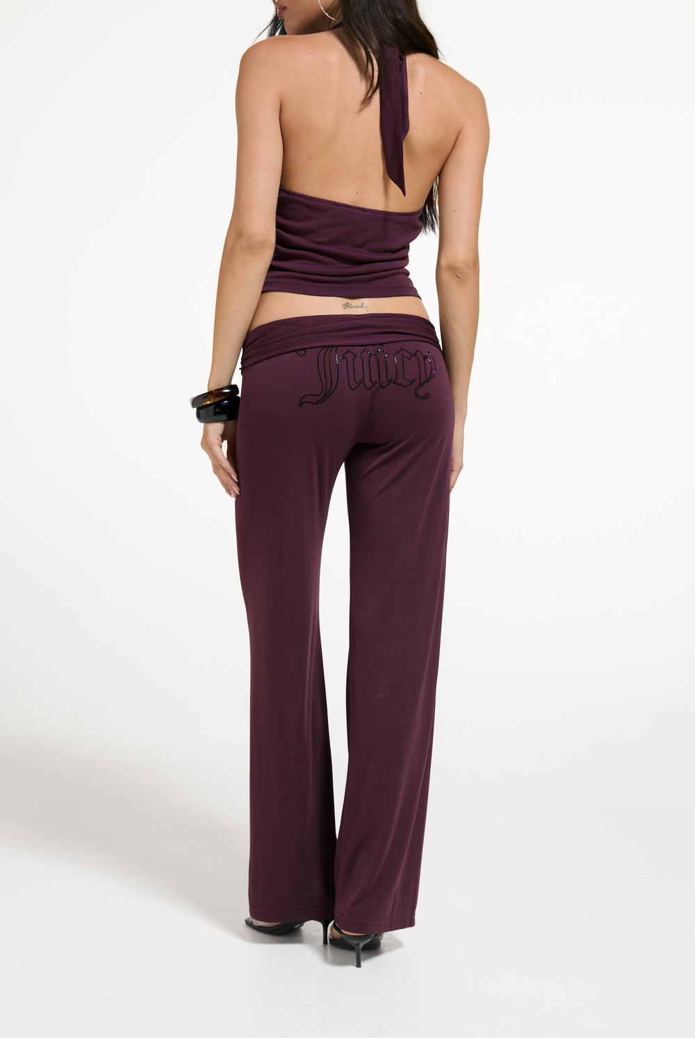 Displays a model wearing the Winetasting 'Juicy' branded Belted Flare Trousers