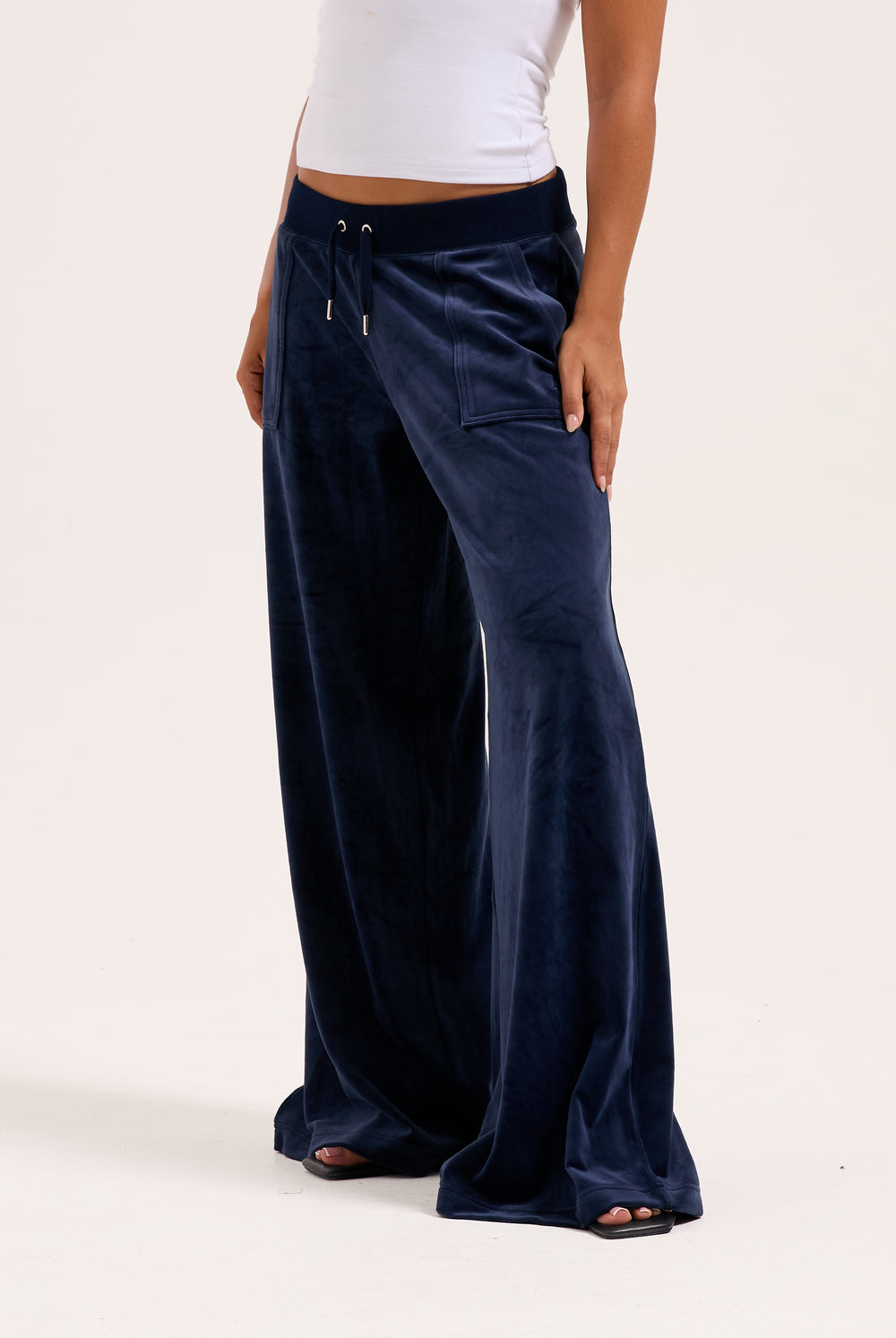 Displays a model wearing the night sky 'juicy' branded Sky Wide leg classic velour track pant 