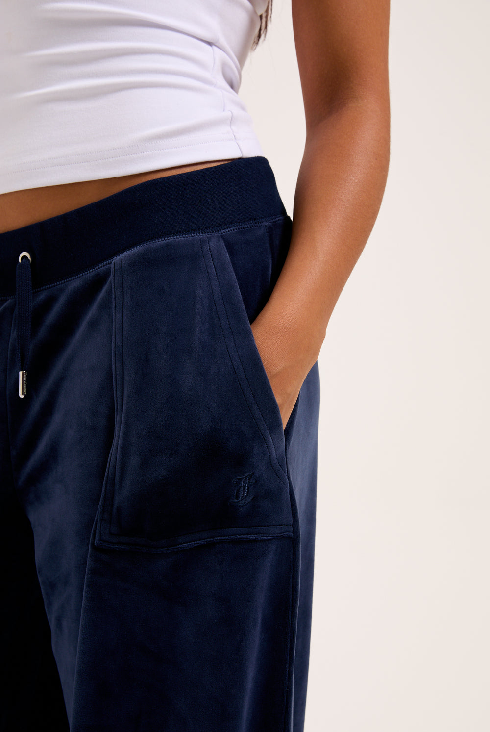 Displays a model wearing the night sky 'juicy' branded Sky Wide leg classic velour track pant 