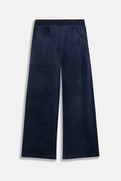 Displays a model wearing the night sky 'juicy' branded Sky Wide leg classic velour track pant 