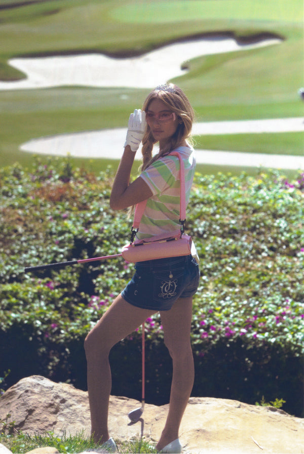 Displays a model wearing the green pink stripe 'Juicy' branded puff sleeve polo top 